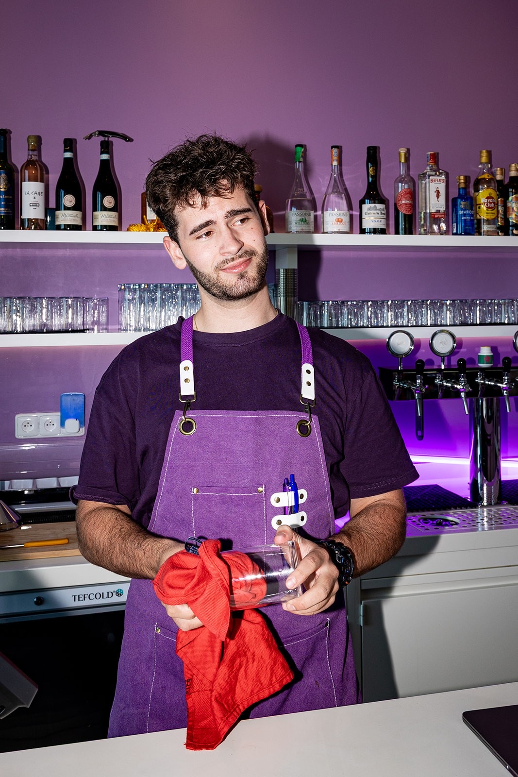 Za barem restaurace BBCREW s fialovým neonem